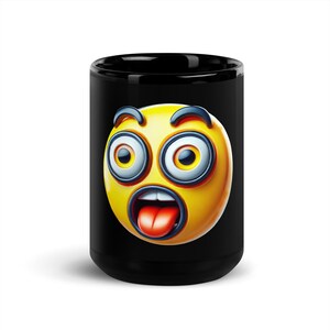 May include: Black ceramic mug featuring a surprised emoji face. The emoji has a yellow face with wide eyes, a gaping mouth, and a red tongue. The mug is a standard size and shape.