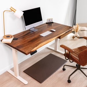 Standing desk crafted from walnut wood with sleek white legs and a convenient drawer for storage. This standing height desk with drawers combines functionality with style, perfect for those seeking a practicality in their workspace