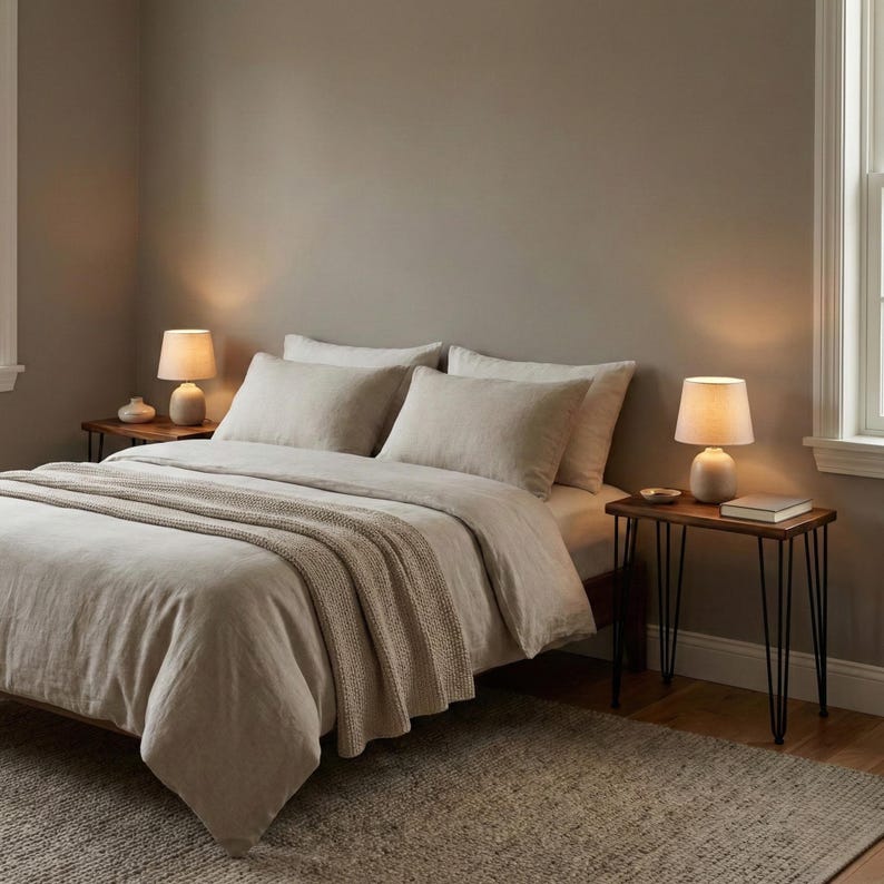 May include: Walnut nightstand with solid wood top and black hairpin metal legs, styled beside a bed with lamps in a cozy modern bedroom.