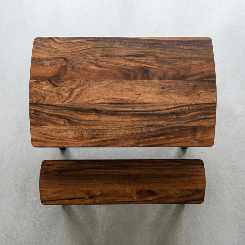 May include: A rectangular solid wood dining table with a dark walnut finish and black legs. The walnut dining table with the bench is set on the grey background. The table is approximately 48 inches long.