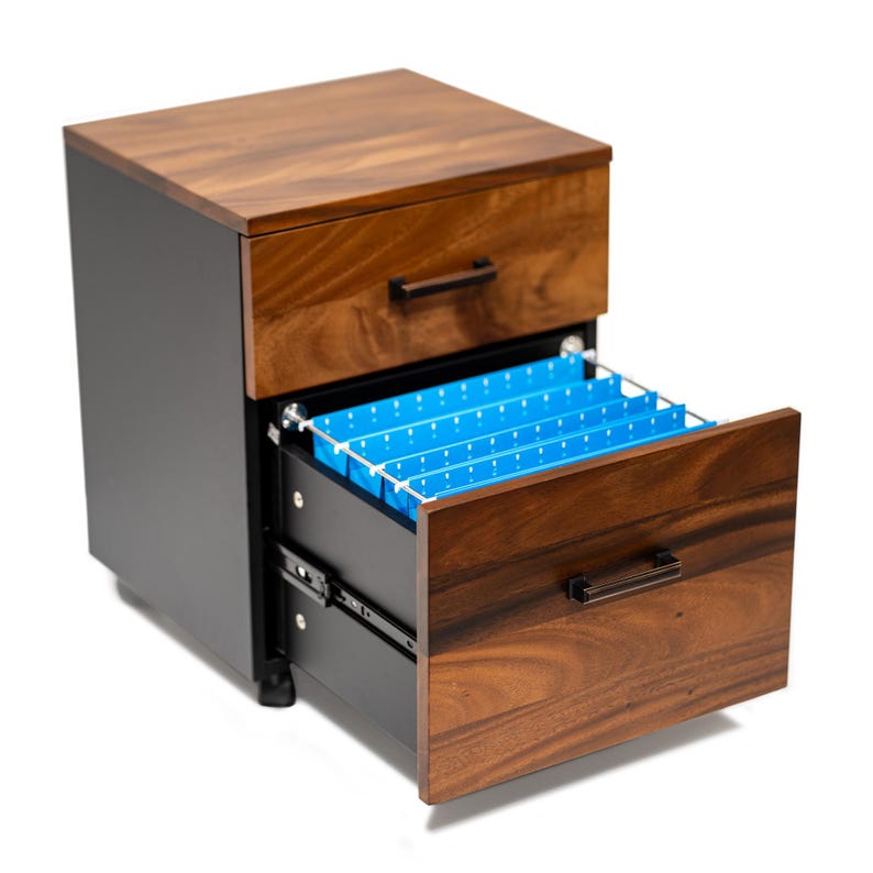 May include: A two-drawer filing cabinet with a walnut finish. The top drawer is closed, and the bottom drawer is open, revealing blue file folders.