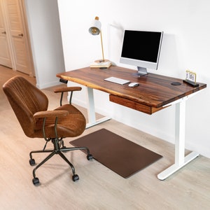 Modern wood standing computer desk featuring walnut hardwood with a natural live edge, complemented by white legs and drawer for storage. This adjustable wood table merges contemporary design with functionality, ideal for any sleek, modern workspace.