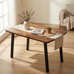 Walnut dining table with solid wood rectangular top, rich natural wood grain, black metal legs, and modern dining room decor in a bright home interior.
