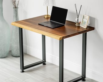 May include: A wooden desk with a live edge and black metal legs. A laptop sits on the desk, along with a small lamp, a framed picture, and a vase with reeds. The desk is approximately 76 cm wide.