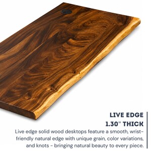 Close-up of a handcrafted solid walnut live edge desk top showing rich natural wood grain, smooth wrist-friendly edge, 1.30 inch thickness, knots, color variations, and cable grommet hole.