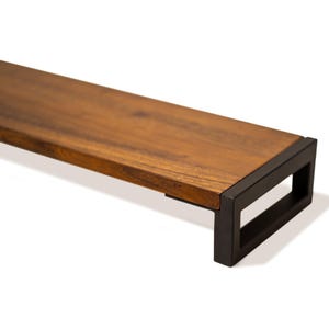 May include: Walnut monitor stand close-up with solid wood shelf, rich natural walnut grain, and black metal legs on a clean white background.