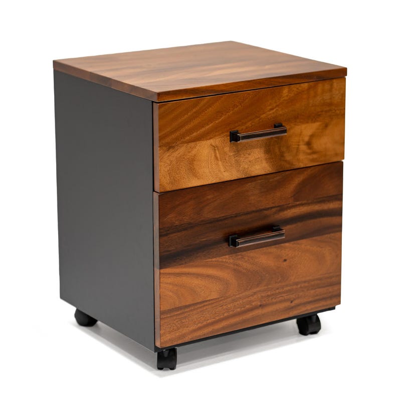 May include: A two-drawer mobile file cabinet with a black base and a wood top. The drawers have walnut wooden fronts with dark brown metal handles.
