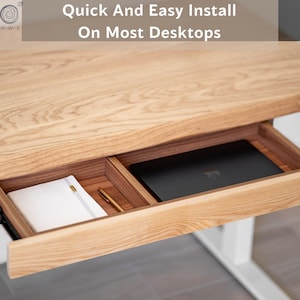 May include: A light-colored wooden desk with a pull-out drawer. The drawer contains a laptop, a notebook, and a pen. The text "Quick And Easy Install On Most Desktops" is visible at the top of the image.