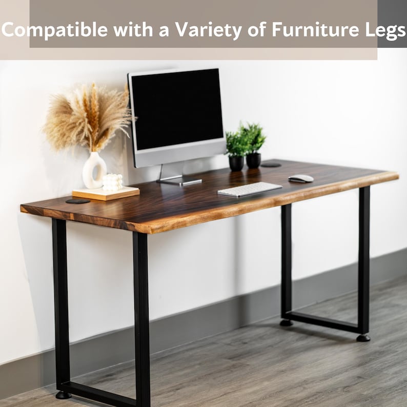 May include: A wooden computer desk top with black metal legs. The desktop has a live edge and is compatible with a variety of furniture legs. The desk is shown with a computer monitor, keyboard, mouse, and plants.