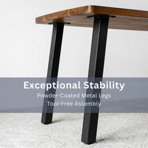May include: A rectangular walnut dining table with a rich brown finish. It features black, powder-coated metal legs with adjustable feet for stability. The image includes the text "Exceptional Stability".