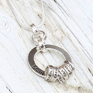Sterling silver necklace for Grandmother with tiny rings stamped with grandkids names, around a washer.