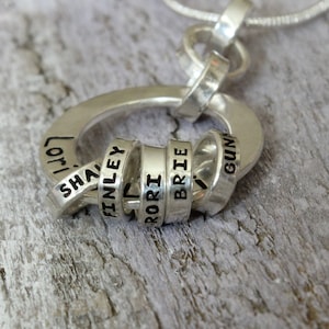 Sterling silver necklace for Grandmother with tiny rings stamped with grandkids names, around a washer.