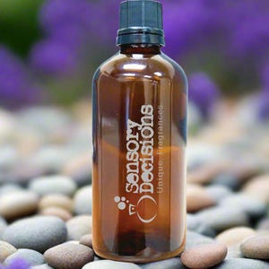 Puede incluir: Una botella de vidrio marrón con una tapa negra. La botella está etiquetada con "sensory decisions" y "unique fragrances".