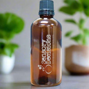 May include: A brown glass bottle with a black cap, containing a clear liquid. The bottle has the text "Sensory Decisions, Unique Fragrances" in white. The bottle is approximately 7 inches tall.