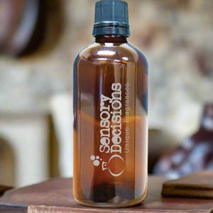 Puede incluir: Una botella de vidrio marrón con una tapa negra y el texto "Sensory Decisions Unique Fragrances" grabado en la parte delantera.