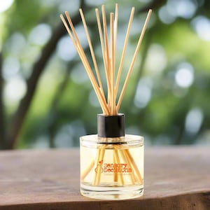 May include: A clear glass bottle diffuser with a black lid and wooden sticks. The bottle has a label that reads "Sensory Decisions Unique Fragrances".