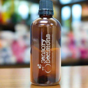 May include: A brown glass bottle with a black cap. The bottle is labelled "Sensory Decisions, Unique Fragrances".