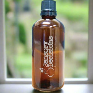 Könnte beinhalten: Eine braune Glasflasche mit schwarzem Deckel. Die Flasche ist mit "Sensory Decisions. Unique Fragrances." beschriftet.