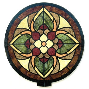 Pode incluir: Um design de vitral redondo com um motivo floral. O design apresenta uma flor central de quatro pétalas, cercada por quatro folhas. As cores são vermelho, verde, amarelo e marrom.