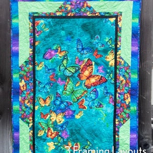 May include: A quilting pattern featuring a colorful butterfly design with a turquoise background. The pattern is called "Panel Frames" and is by "Swirly Girls". It includes 3 framing layouts.