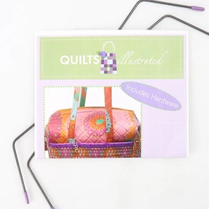 Può includere: Una colorata borsa trapuntata con un design floreale, esposta su una superficie bianca. La borsa è rosa, arancione e viola, con un motivo trapuntato. L'immagine include il testo "QUILTS illustrated" e "Includes Hardware".