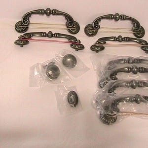 May include: A set of three ceramic mugs with a speckled, matte finish. The mugs are in shades of cream, light gray, and dark gray. Each mug has a simple, minimalist design and a rounded handle.