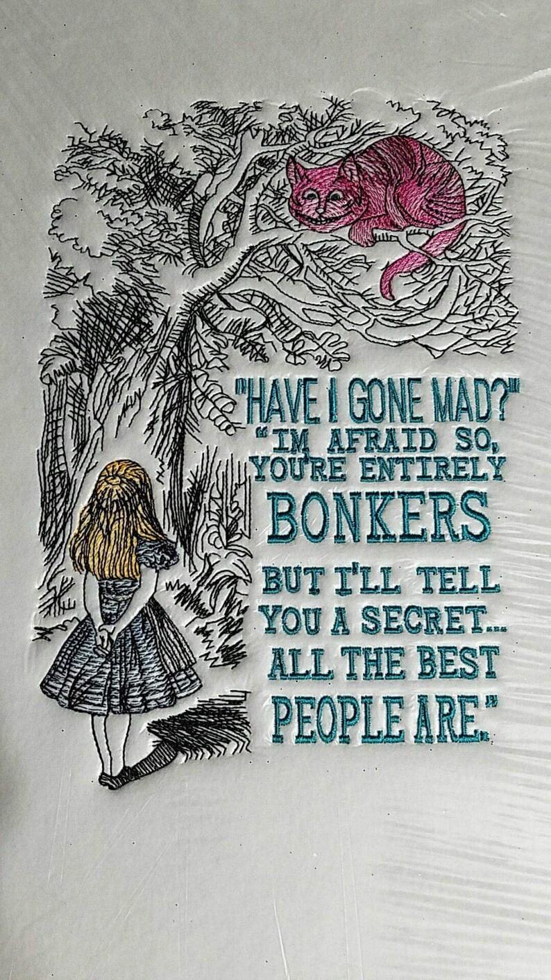 Op de afbeelding: Geborduurde afbeelding van Alice uit Alice in Wonderland die in een bos staat met een Cheshire Cat in een boom erboven. De tekst luidt "Ben ik gek geworden?" "Ik vrees van wel, je bent helemaal gek, maar ik zal je een geheim vertellen... de beste mensen zijn zo."