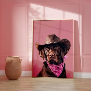 Könnte beinhalten: Ein brauner Labrador Retriever, der einen braunen Cowboyhut und ein pinkfarbenes Bandana vor einem rosafarbenen Hintergrund trägt.