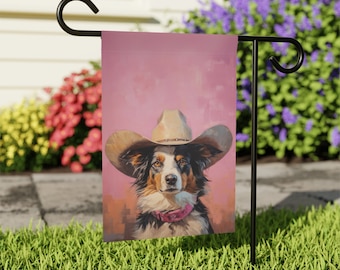 Peut inclure: Un drapeau de jardin avec un fond rose représentant un chien noir et blanc portant un chapeau de cowboy marron. Le chien regarde directement le spectateur.
