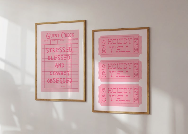 May include: Two framed pink prints with gold frames. One print reads "Guest Check" with the text "Stressed, Blessed, and Cowboy Obsessed." The other print features three pink tickets that read "Howdy Y'all."