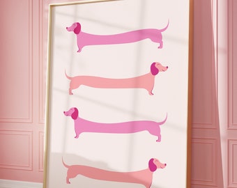 Puede incluir: Una impresión enmarcada con cuatro perros salchicha rosas en fila, cada uno con un tono de rosa diferente. Los perros están todos mirando hacia la derecha y tienen la lengua fuera.