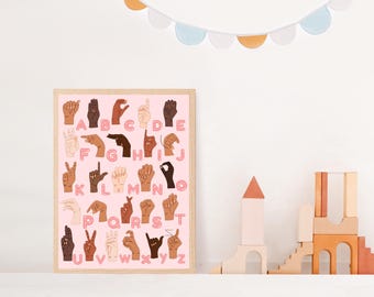May include: A pink poster with the alphabet in American Sign Language. Each letter is represented by a different hand gesture. The hands are diverse in skin tone.