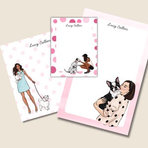 May include: Stationery set featuring illustrations of women with dogs. The set includes notepads with pink polka dot borders and the text "Lucy Collier". The illustrations depict a woman walking a dog, petting a Dalmatian, and kissing a Boston Terrier.