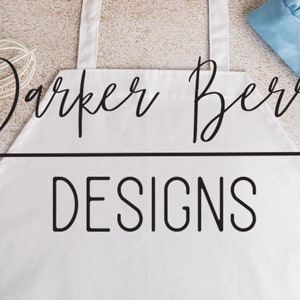May include: White apron with black text that reads "Parker Berry Designs".