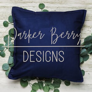 May include: A navy blue pillow with the text "Darker Berry Designs" in white lettering.