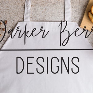 May include: White apron with black text that reads "Parker Berry Designs".