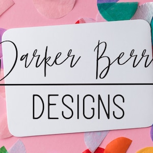 Könnte beinhalten: Eine weiße Karte mit schwarzem Text, der "Darker Berry Designs" lautet. Die Karte ist von buntem Konfetti umgeben.