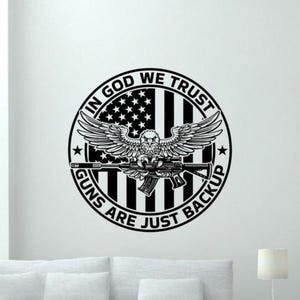 May include: Black and white decal featuring an eagle holding a rifle in front of an American flag. The text reads "In God We Trust Guns Are Just Backup".