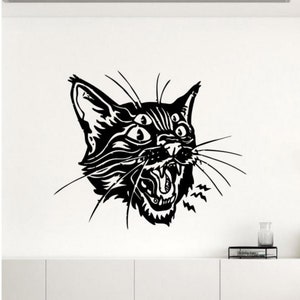 May include: Black and white illustration of a cat with four eyes, an open mouth, and a jagged, pointed design. The cat is looking to the right and has a few whiskers.