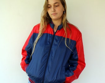 May include: A blue and red color block jacket with a zipper closure. The jacket has a ribbed hem and cuffs.