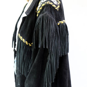 May include: Black suede jacket with fringe detailing and yellow and black braided trim. The jacket has a southwestern style.
