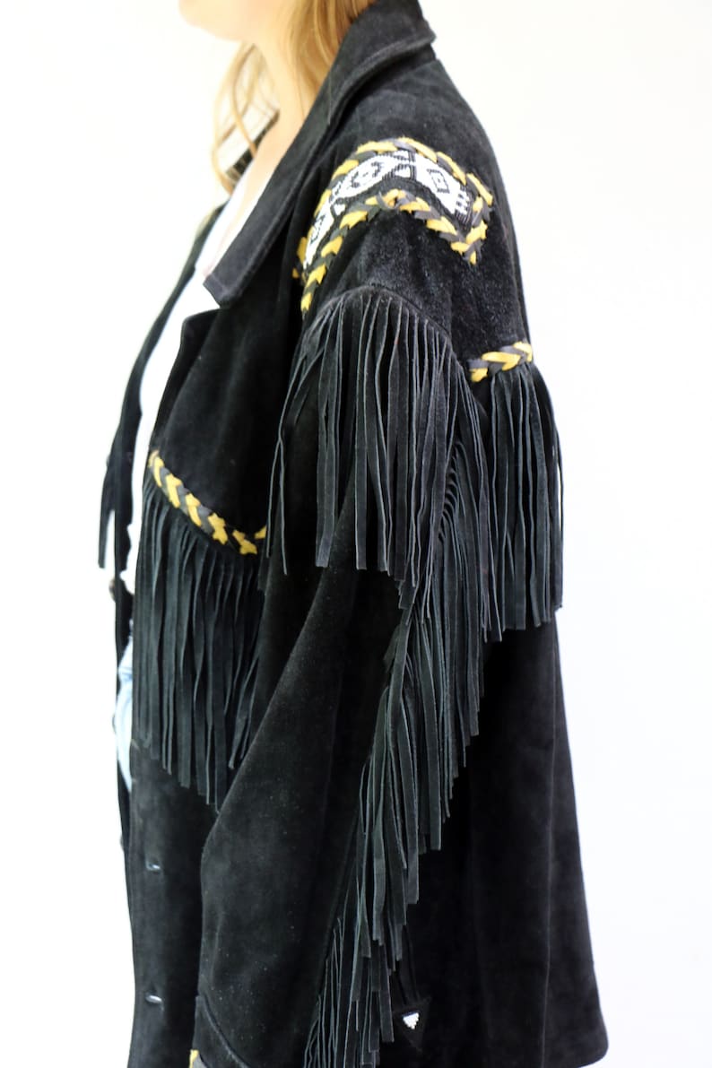 May include: Black suede jacket with fringe detailing and yellow and black braided trim. The jacket has a southwestern style.