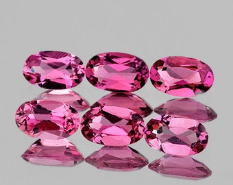 Puede incluir: Seis piedras preciosas ovaladas de color rosa, probablemente turmalinas, dispuestas en dos filas de tres. Las piedras preciosas están facetadas y tienen un acabado brillante.