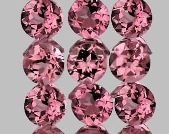 Puede incluir: Nueve piedras preciosas redondas de color rosa, probablemente turmalinas, dispuestas en tres filas de tres. Las piedras preciosas están facetadas y tienen un ligero brillo.