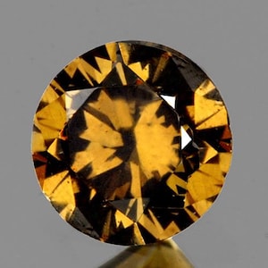 May include: A round, faceted gemstone with a dark brown to golden brown color. The gemstone has a unique, star-like pattern within its structure.