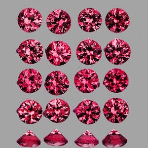 May include: A collection of round, faceted, deep pink gemstones. The gemstones are arranged in rows and columns, with some showing a side profile. The gems have a brilliant cut, reflecting light.