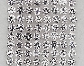 Pode incluir: Uma coleção de 64 gemas redondas, transparentes e facetadas dispostas em uma grade. As gemas são todas do mesmo tamanho e forma, e estão dispostas sobre um fundo branco.