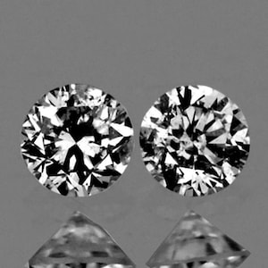 May include: Two round, clear, brilliant cut diamonds. The diamonds are set in a silver setting.