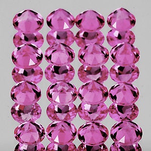 Puede incluir: Un grupo de 15 piedras preciosas ovaladas de color rosa, cada una con un corte facetado. Las piedras preciosas est&aacute;n dispuestas en tres filas de cinco, con cada fila ligeramente desplazada de la que est&aacute; arriba.