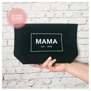 May include: Black canvas zippered pouch with a white rectangle that says "MAMA EST. 2020".